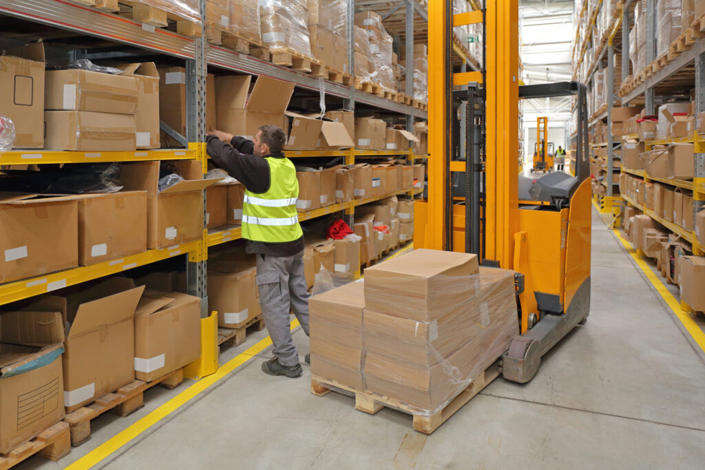 Warehouse Worker Pulling Boxes Down to Fulfill an Order.