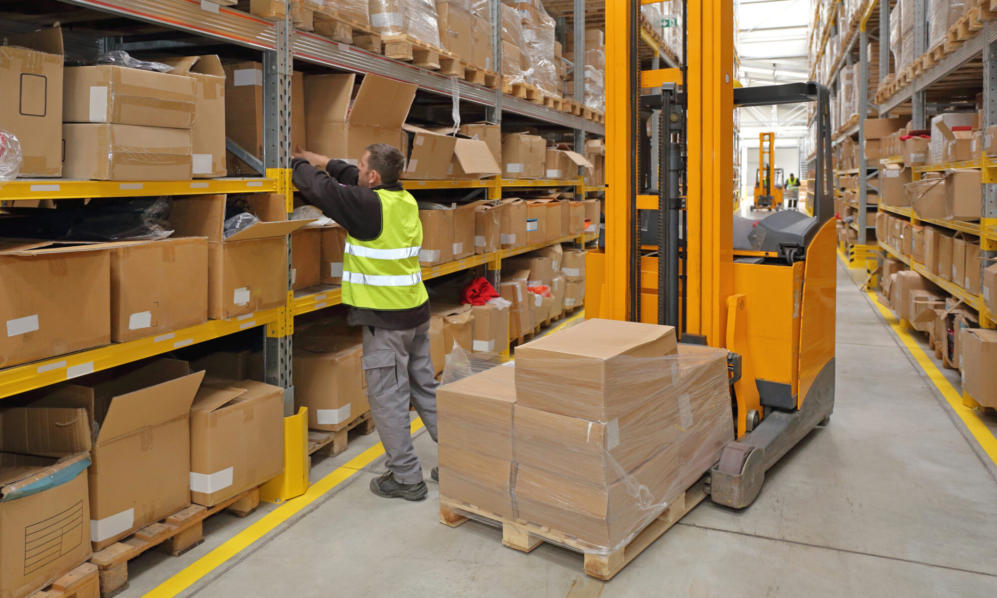 Warehouse Worker Pulling Boxes Down to Fulfill an Order.